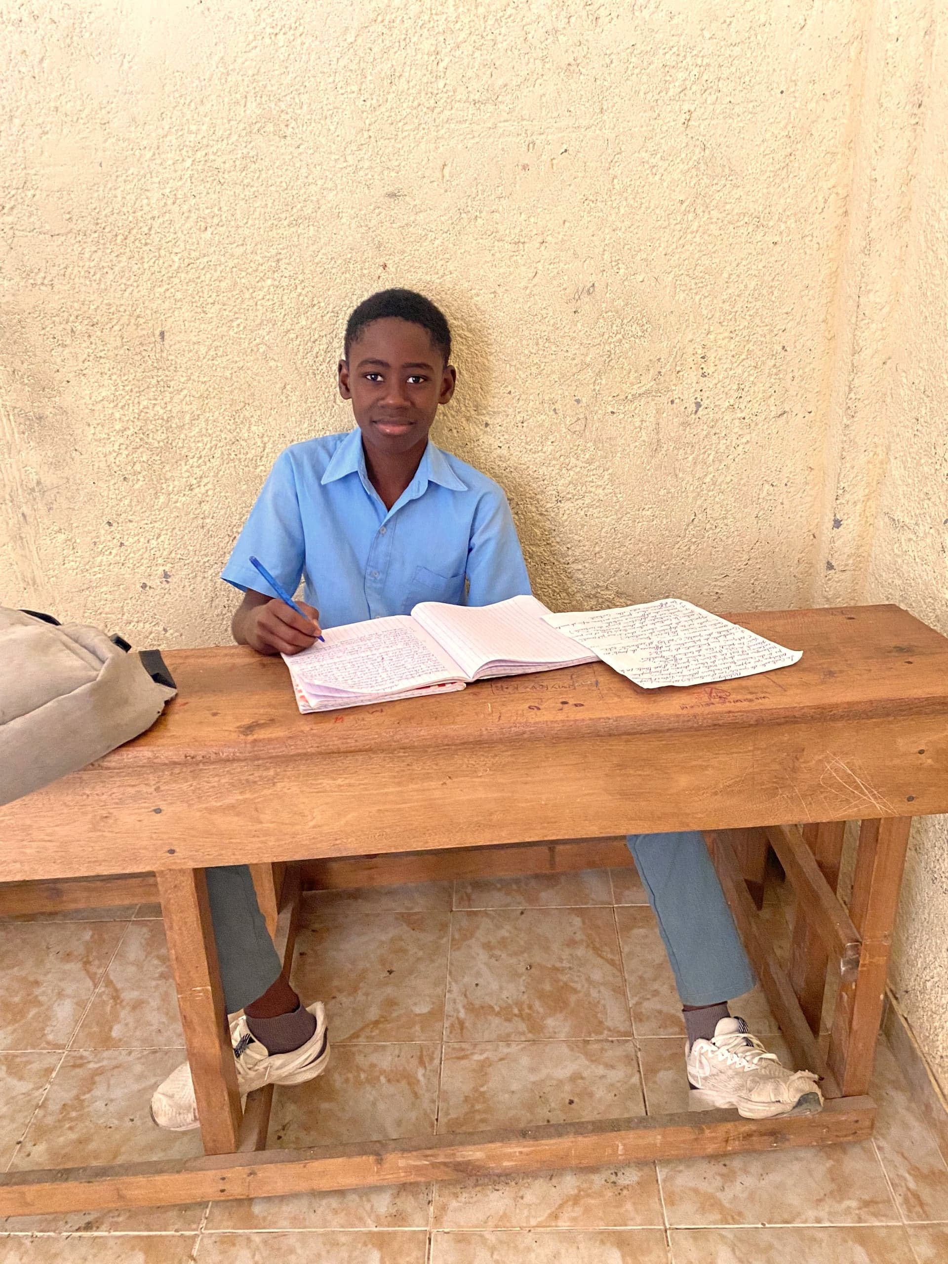 A student studies at a wooden desk in an HEF classroom