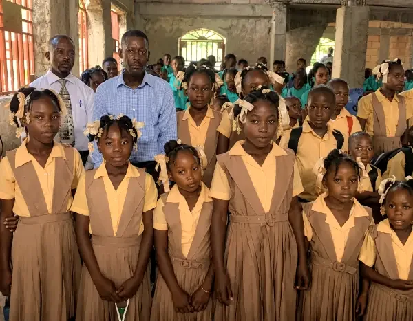 Students in yellow uniforms gather at an HEF school event