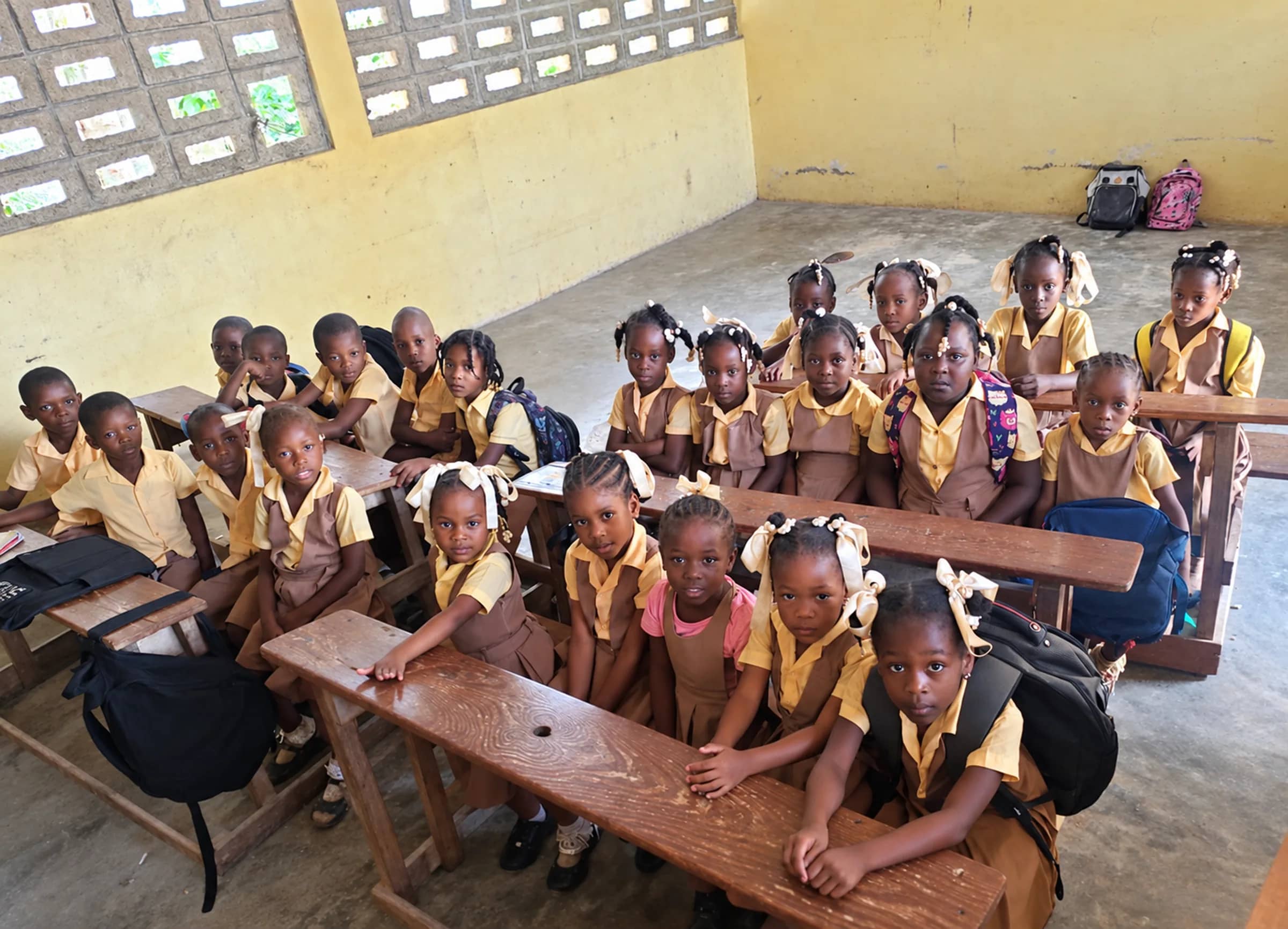 Young students in brown and yellow uniforms fill the desks of an HEF classroom